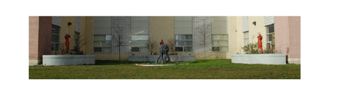 image of garden with school building behind it. Red sculptures can be seen around the outside.