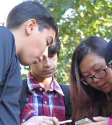 A group of students looking at a phone.