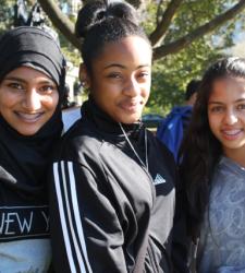 Three students smiling at the camera.