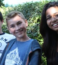 Three students smiling at the camera.
